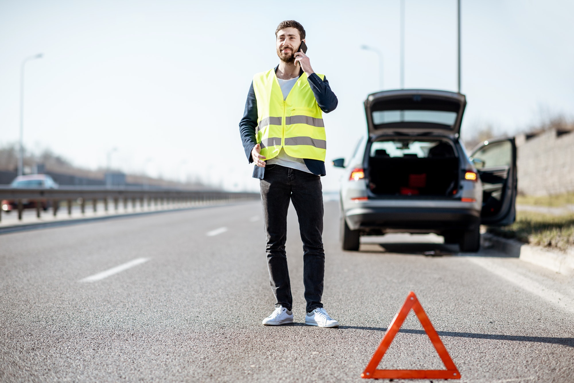 Man calling road assistance on the highway